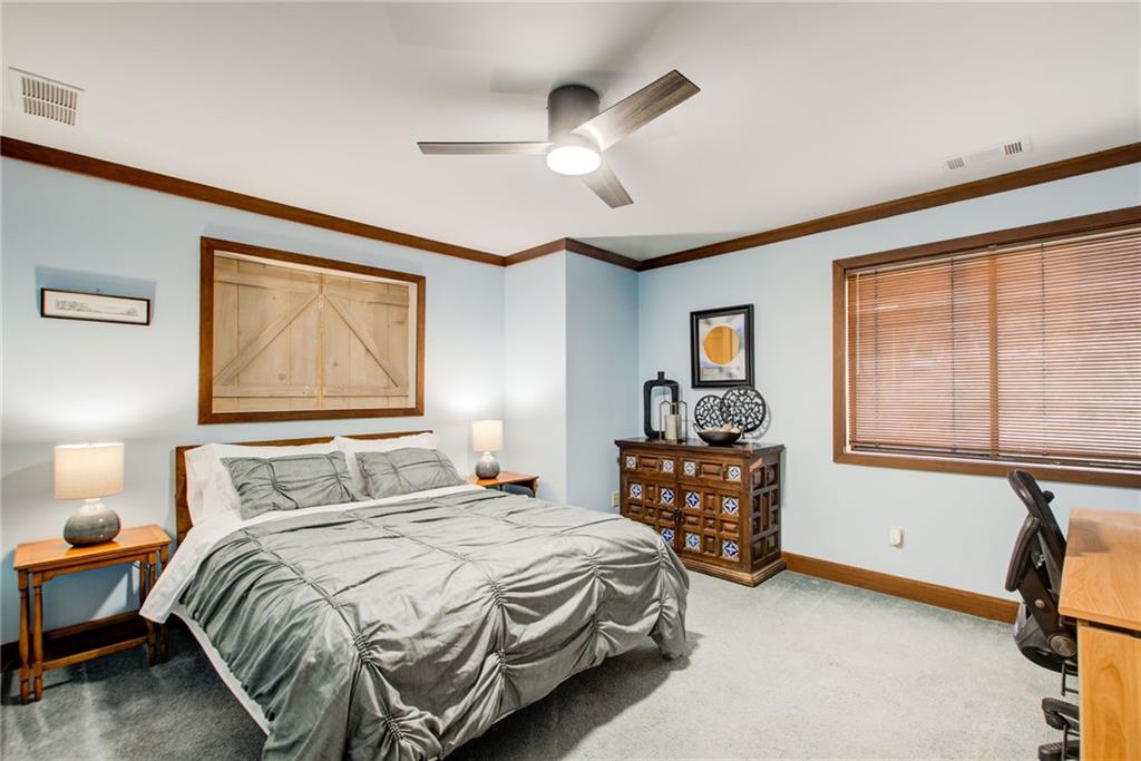 Bedroom featuring light carpet, ceiling fan, and crown molding