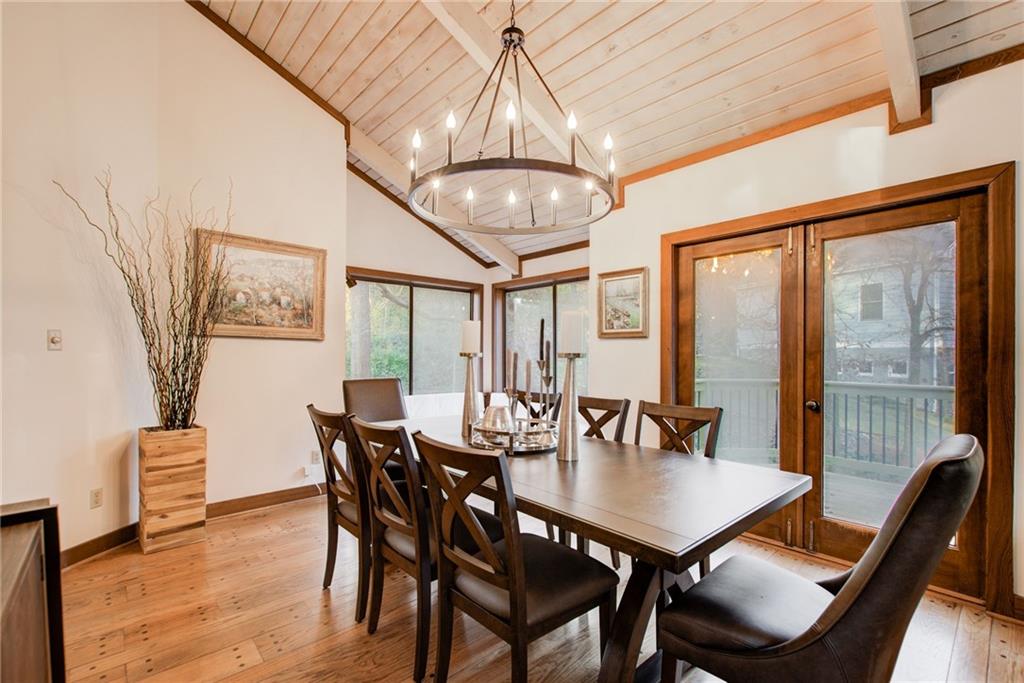 Dining featuring vaulted wood  ceiling, a designer chandelier, hardwood  floors and French  doors that lead to a new deck.