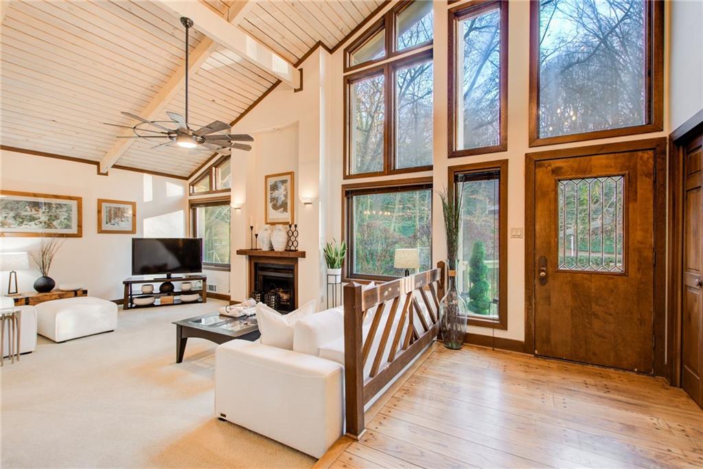 Living room with a with lots of sunlight, l hardwood / wood flooring, and high vaulted ceiling