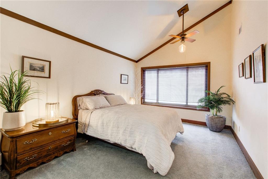 Bedroom featuring dark carpet, ceiling fan, and high vaulted ceiling
