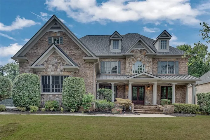 House front features brick and stone exterior with a covered porch.