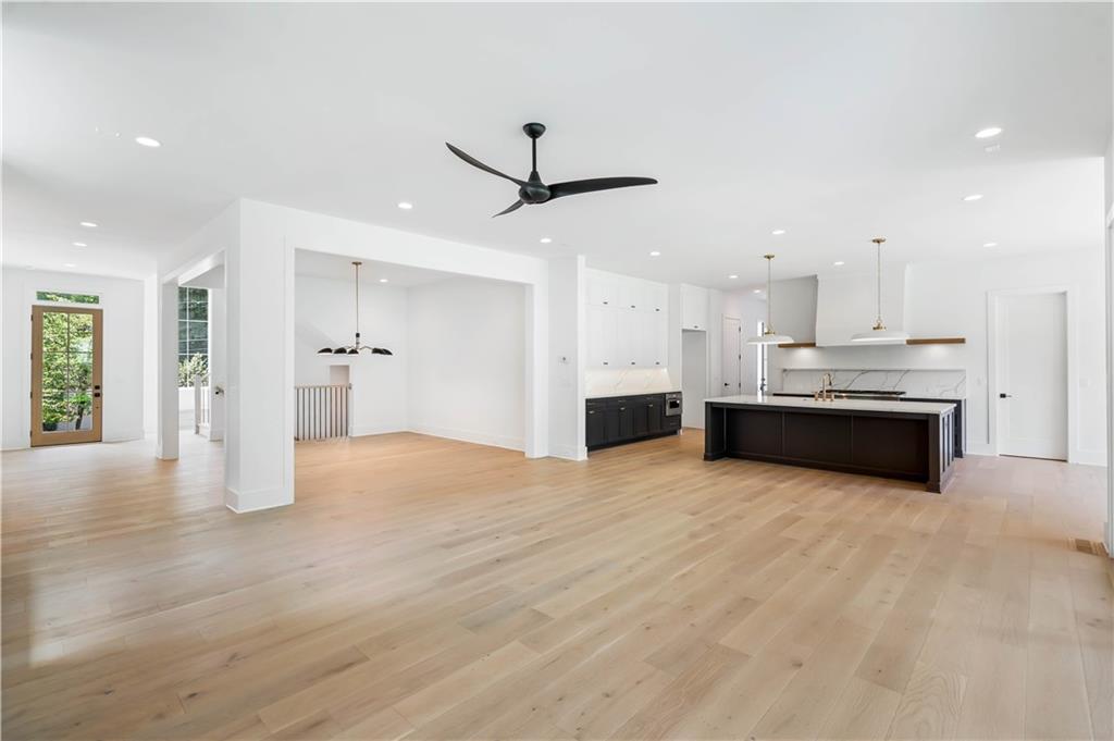 The expansive family room features custom built-ins, an inviting fireplace with a tile/wood accent surround, and western sliding doors leading to the covered outdoor lounge.