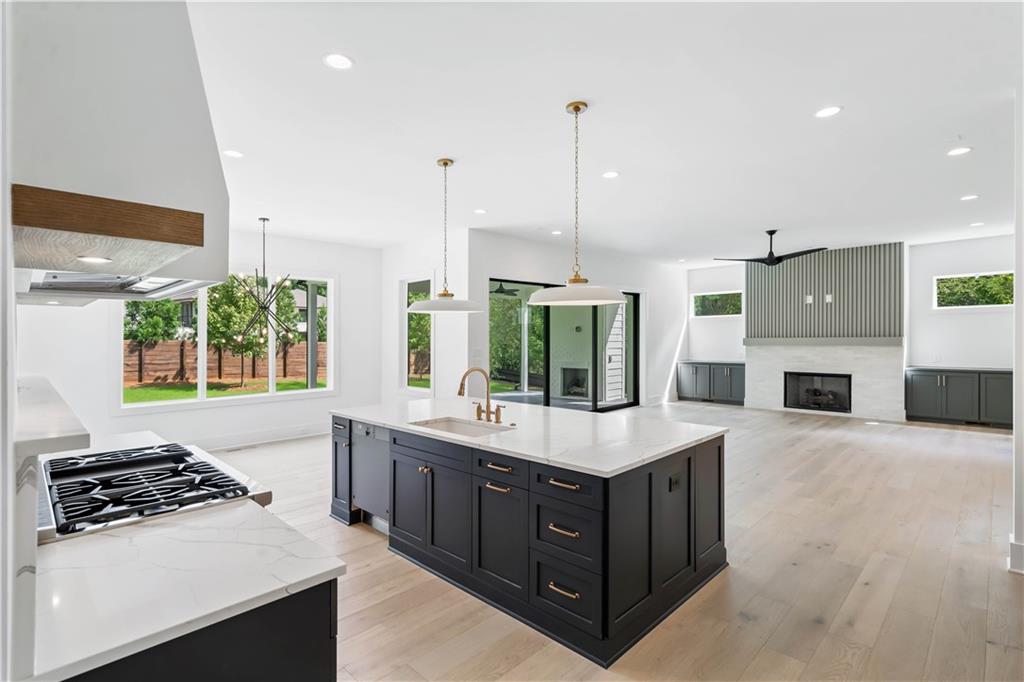 The chef's kitchen is a masterpiece, boasting custom shaker cabinetry with soft-close doors, a quartz backsplash, high-end stainless steel appliances, a custom range hood, and a breakfast area.