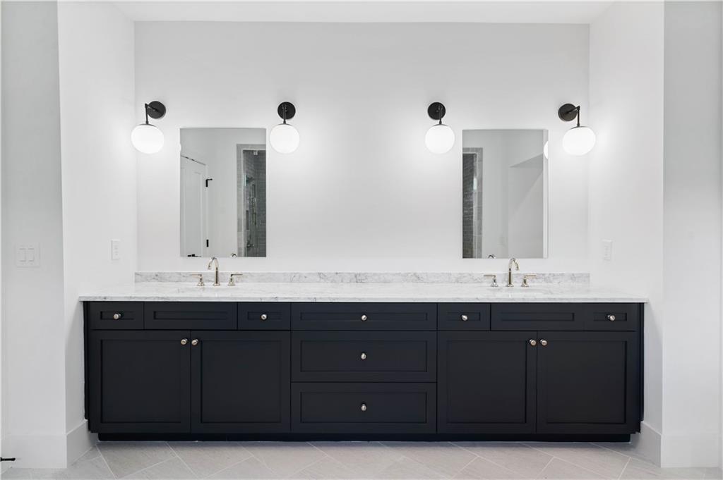 Spa-like bathroom featuring an awe-inspiring wet room with impeccable tile details, a soaking tub, double vanity, large custom closets, and a private water closet.