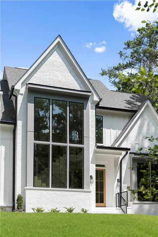 he transitional façade is adorned with verdant landscaping, expansive windows, and a three-car garage.