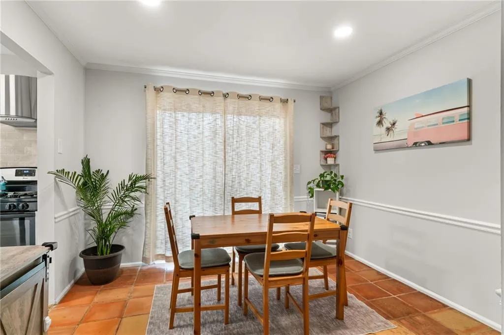 Dining room featuring baseboards, light tile patterned flooring, and crown molding