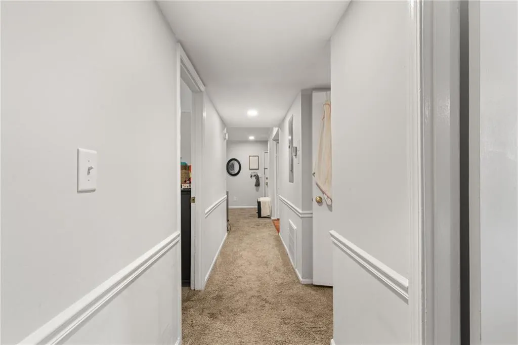 Corridor featuring recessed lighting, light colored carpet, and baseboards
