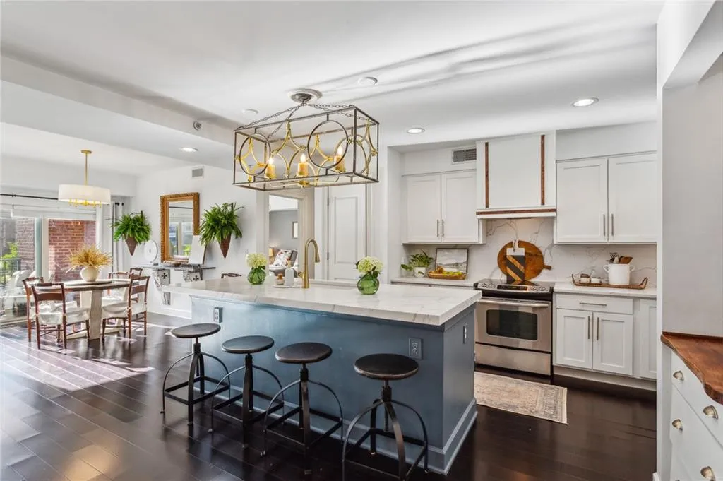 Kitchen featuring hanging light fixtures, dark wood-type flooring, white cabinets, and stainless steel electric stove