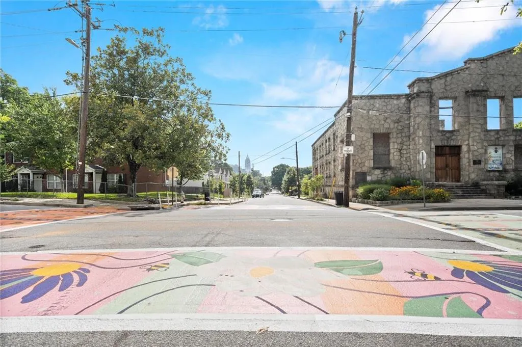 View of asphalt street with sidewalks, curbs, street lights, and traffic signs