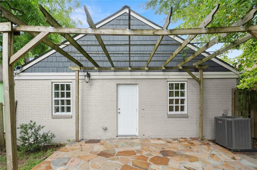 Back of house with a pergola, brick siding, and a patio area