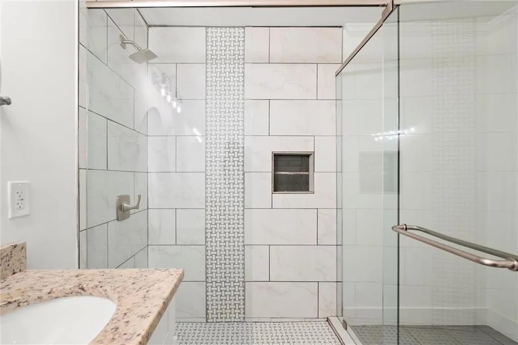 Bathroom with a stall shower, vanity, and tile patterned flooring