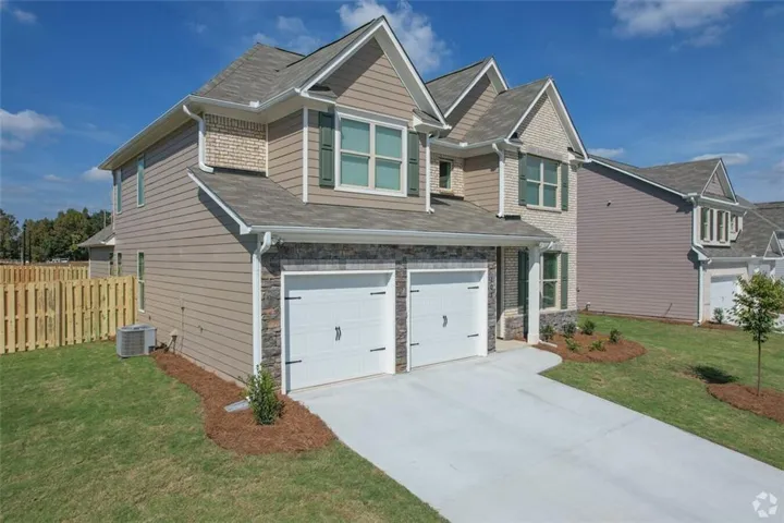 Craftsman-style home featuring a garage, central air condition unit, and a front lawn