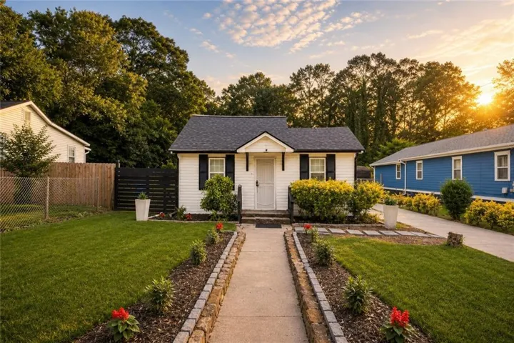 Charming single-story residence featuring white siding and a dark shingle roof