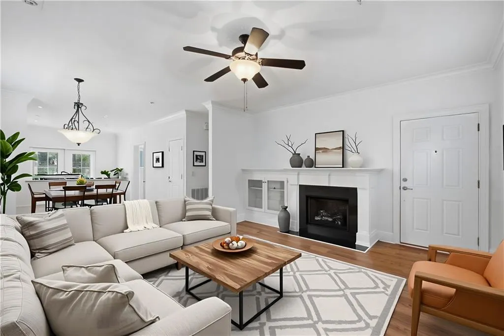 Living area with ornamental molding, wood finished floors, a fireplace, and a ceiling fan