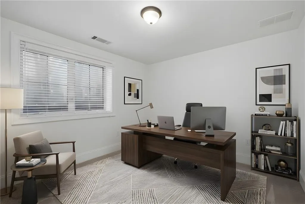 Home office with baseboards and light carpet
