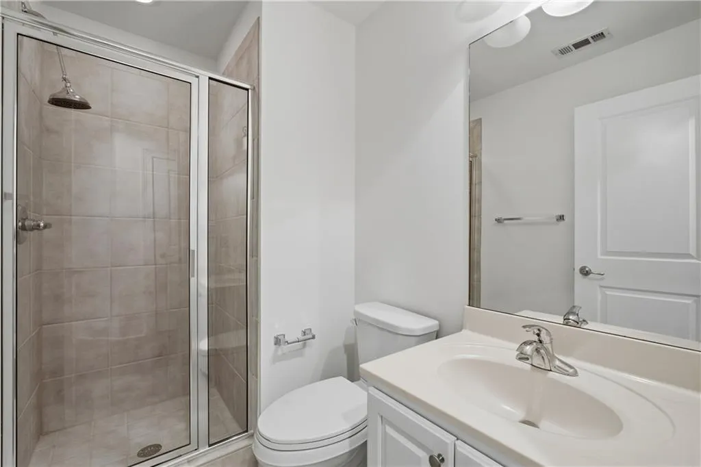 Full bathroom with vanity and a shower stall