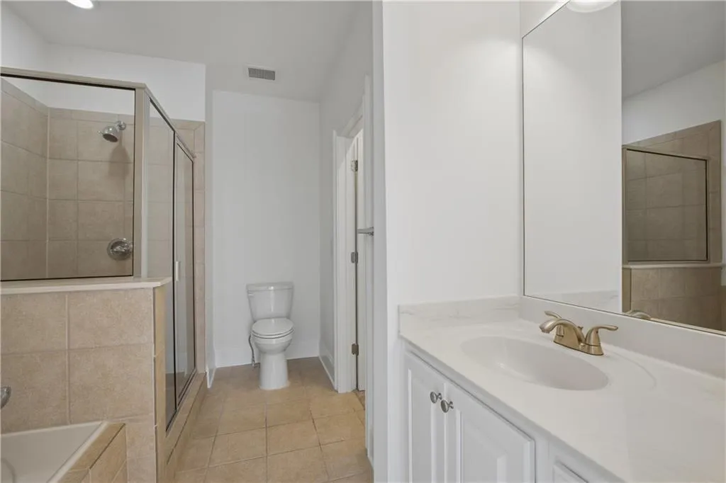 Bathroom with vanity, light tile patterned floors, a shower stall, and tiled tub