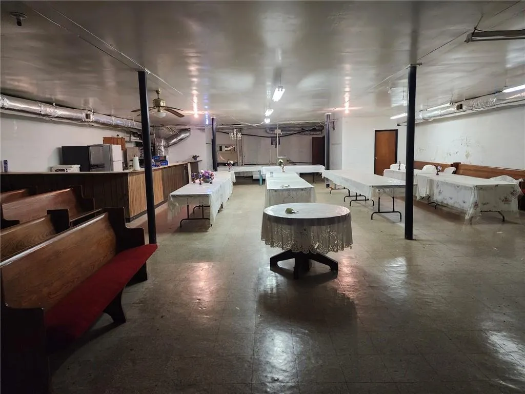 Basement featuring ceiling fan and stainless steel fridge
