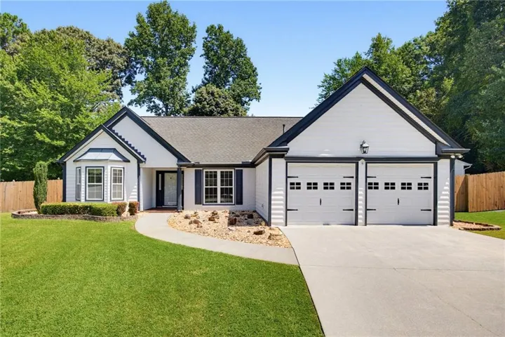 Contemporary single-story residence with white siding and dark trim