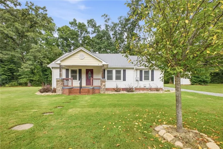 White siding exterior with a metal roof