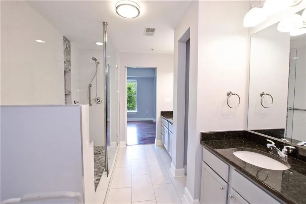 Bathroom with a shower stall, vanity, and tile patterned flooring