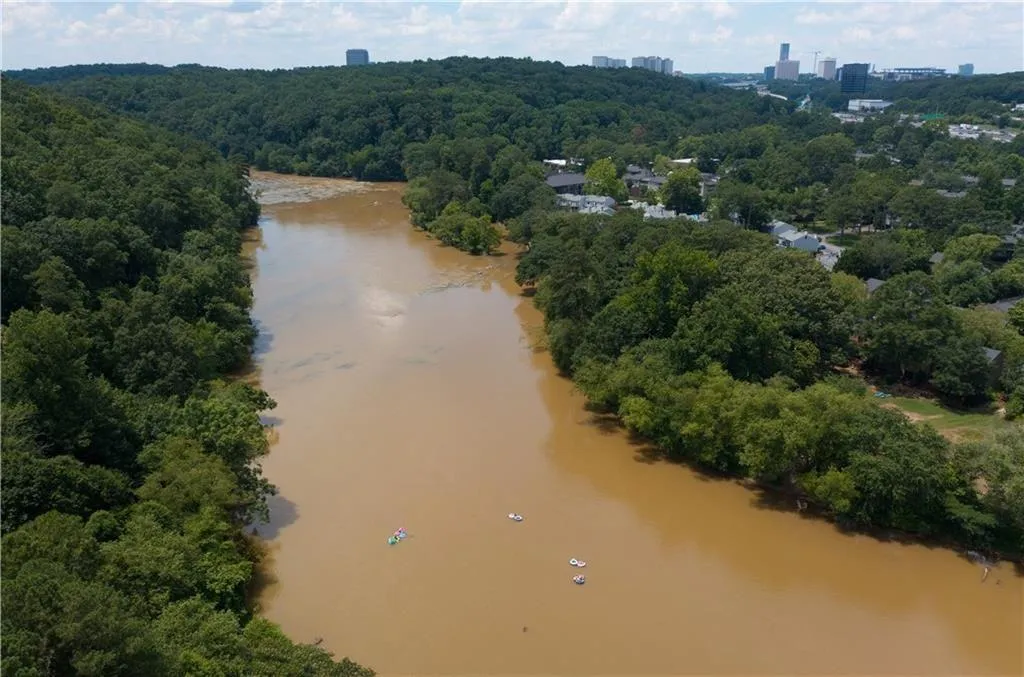 Drone / aerial view of a large body of water and a heavily wooded area