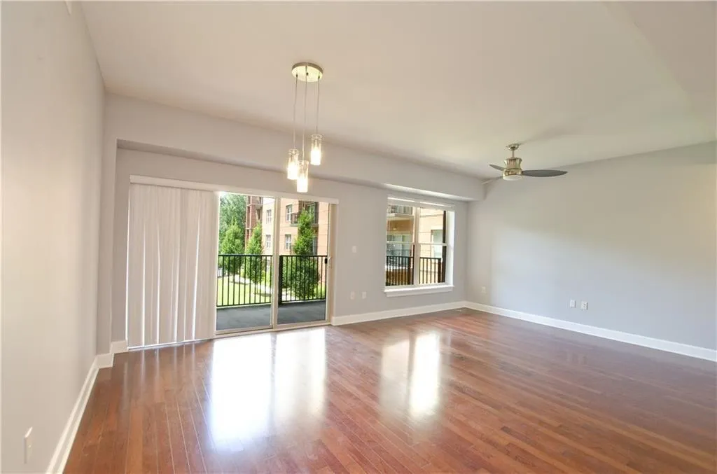 Spare room featuring plenty of natural light, wood finished floors, and a ceiling fan