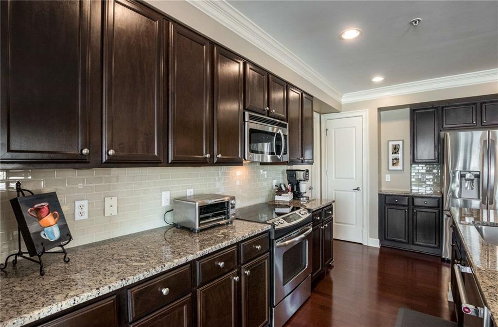 Beautiful custom backsplash and small appliance or cell phone/tablet charging nook next to the refrigerator makes it easy to stay organized and always be able to find your phone!