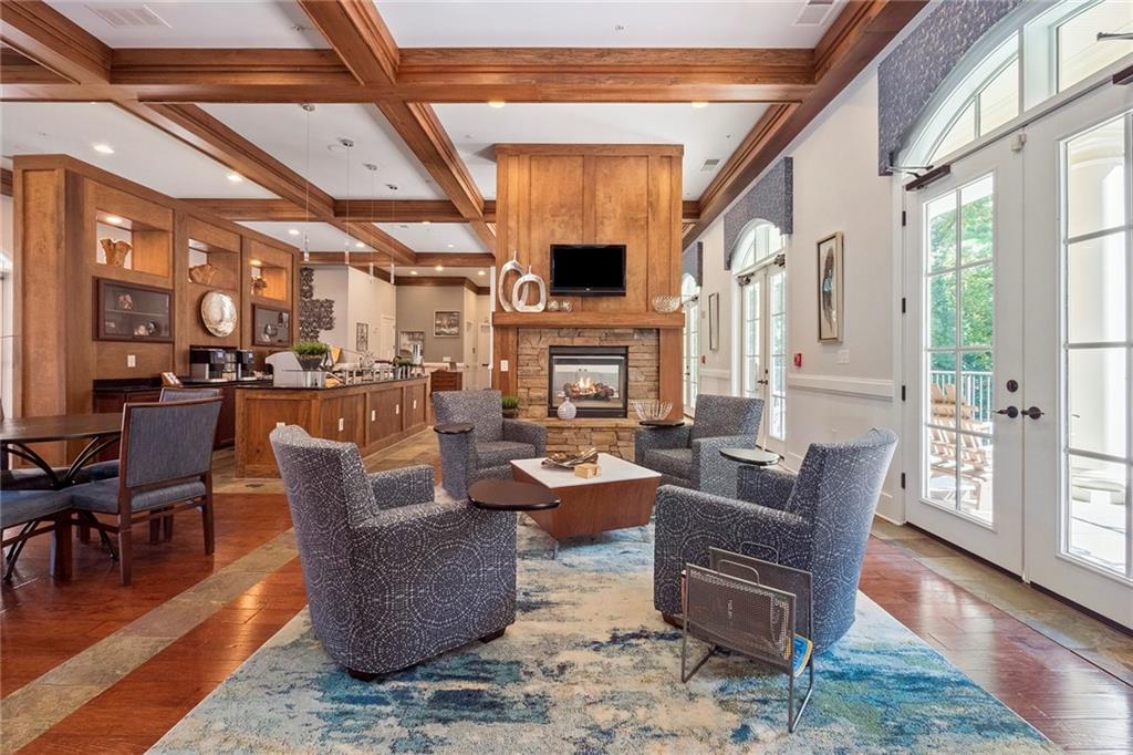There are these wonderful seating areas on either side of the double sided fireplace that are a perfect spot to relax and hang out with your neighbors and guests. They also include 3 sets of french doors that lead to a covered deck with rocking chairs that overlook the two pools and waterfall!