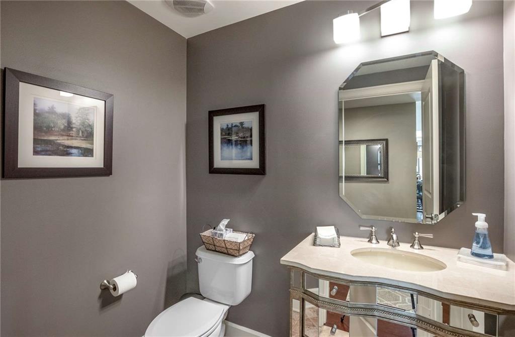 Half bath in the foyer with lovely mirrored vanity.
