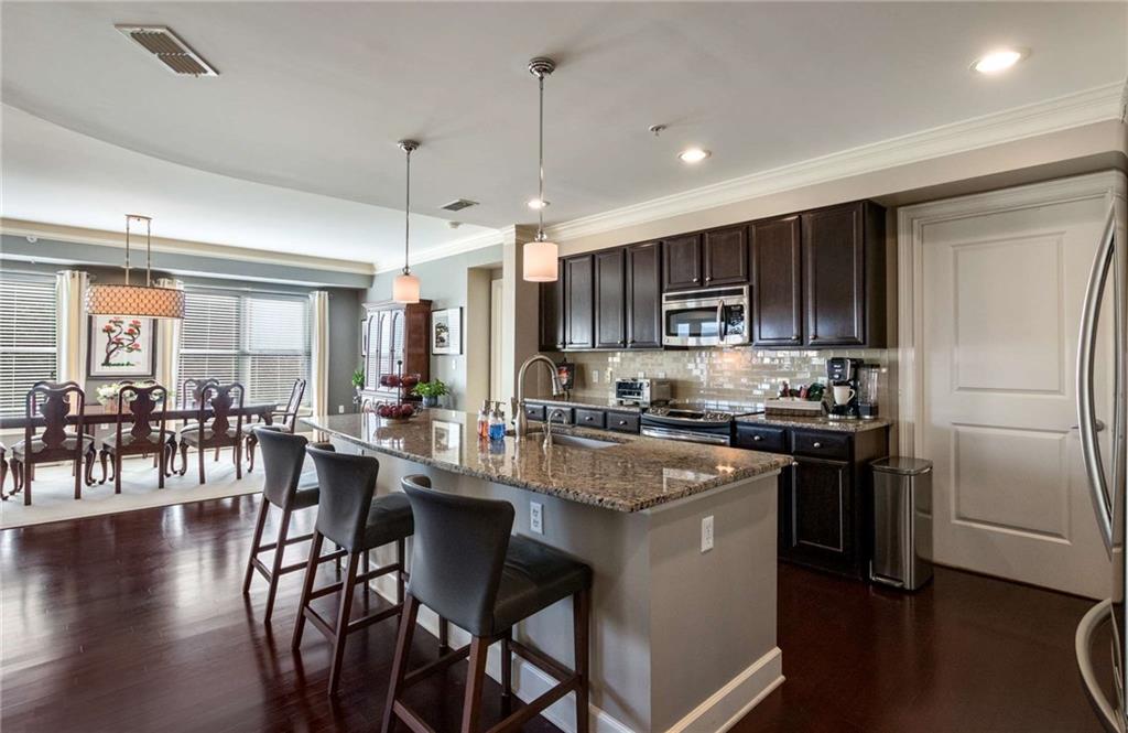 Beautiful custom kitchen is outfitted with newer pendant island lights, halogen under cabinet lights and all stainless steel appliances.  Lots of space for entertaining.