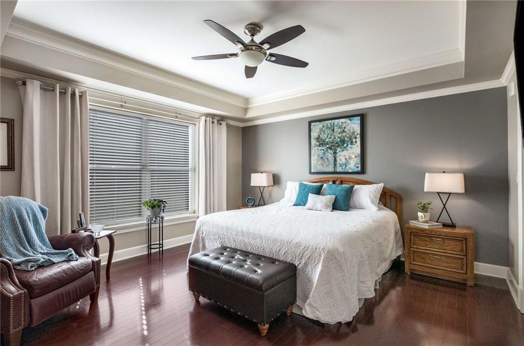 Generously sized primary bedroom suite.  Many other units in the River House have carpet but this one has the same gleaming hardwoods as the living spaces, making the transition to bedroom seemless.  Wonderful creek views from this window.  Easily fit a king sized bed like this one with plenty of space for dressers and night stands.