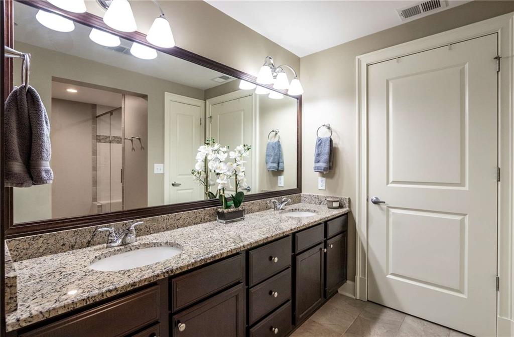Getting ready is not a chore with this double vanity with plenty of storage spaces.  Newer lighting and custom framed mirror are also upgrades that any homewoner will love.