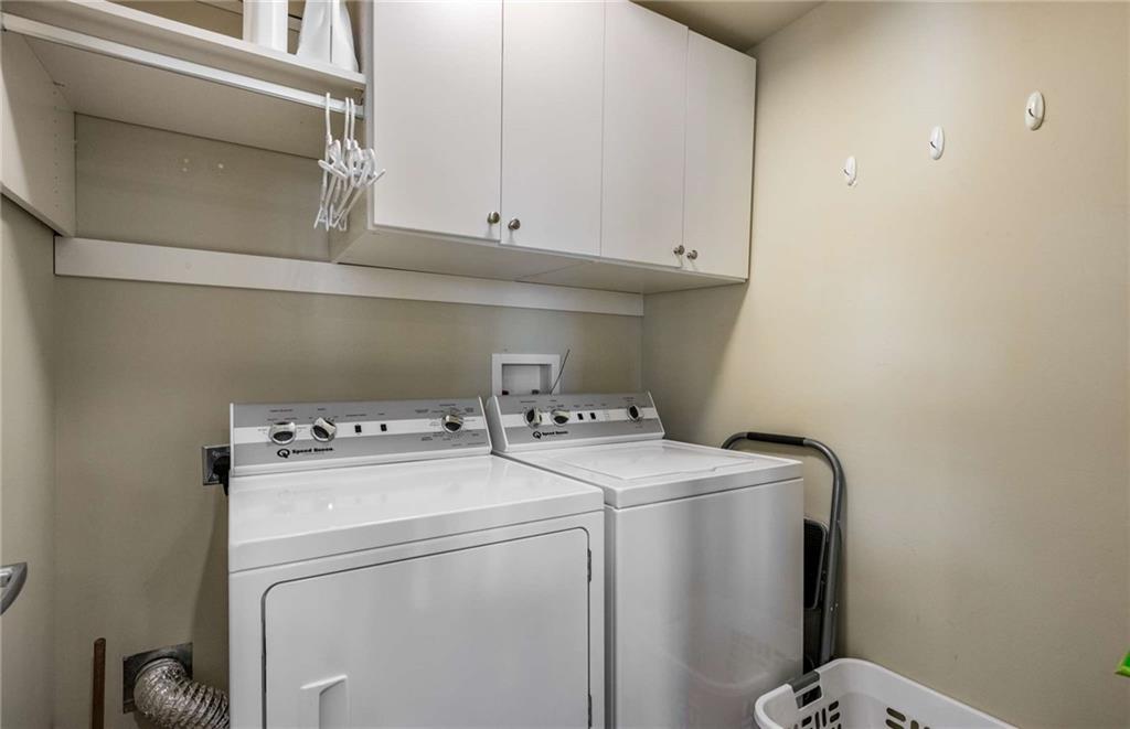 No laundry closet here! Enjoy this spacious laundry room right off the kitchen with cabinets up to the ceiling, shelf space and hanging area.