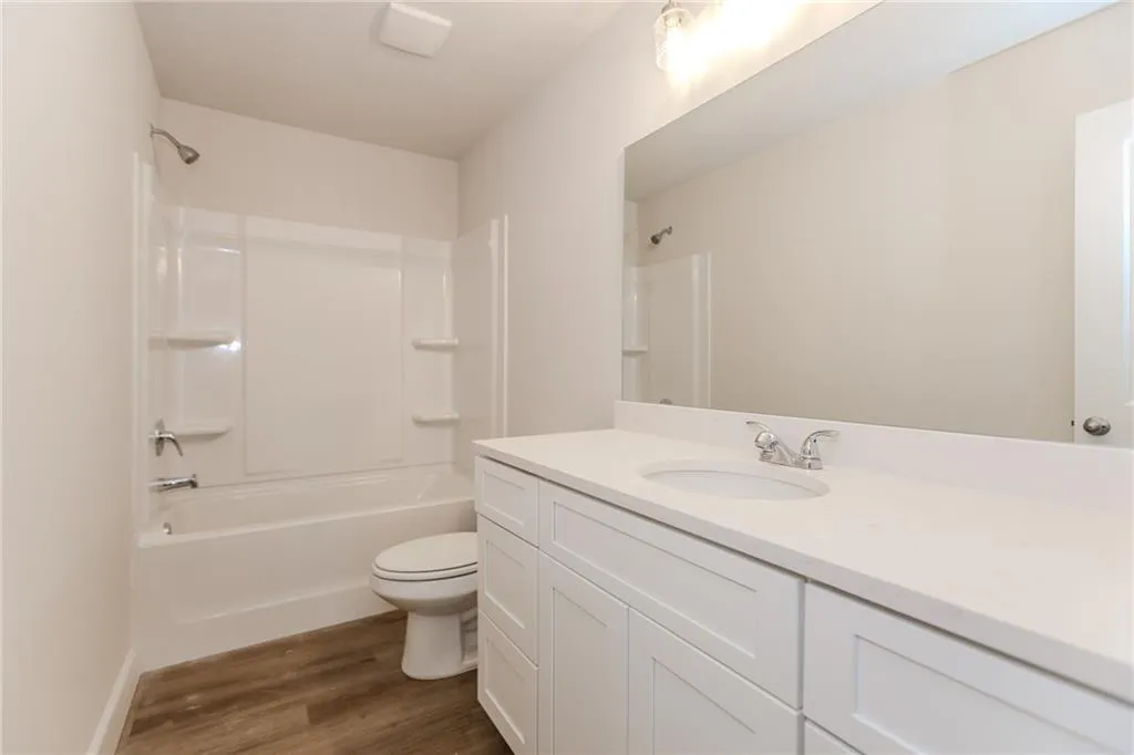 Full bath featuring tub / shower combination, vanity, and dark wood finished floors