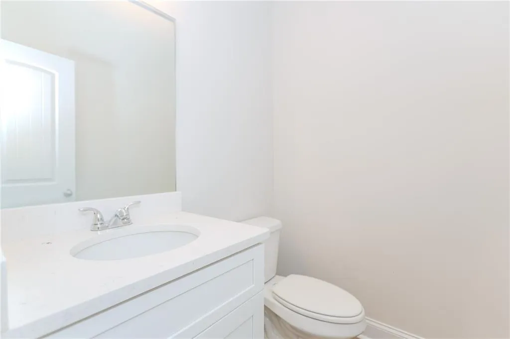 Half bathroom with vanity and toilet