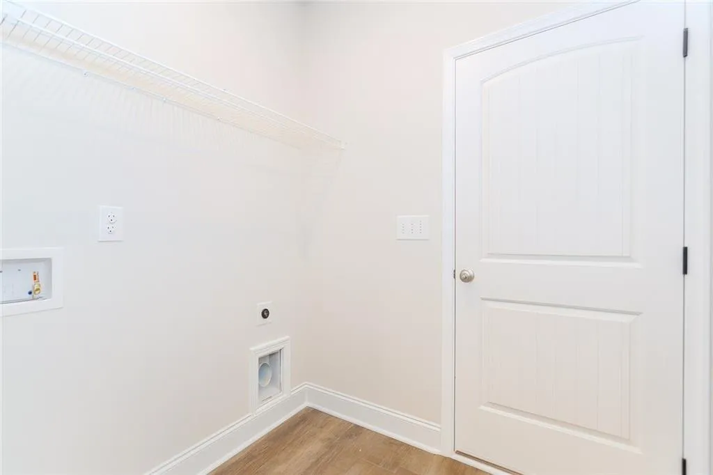 Washroom with light wood-style floors, hookup for an electric dryer, and hookup for a washing machine