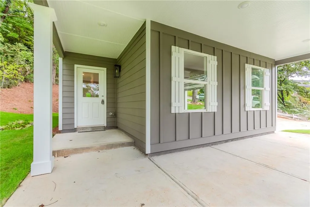 Entrance to property featuring board and batten siding and a porch