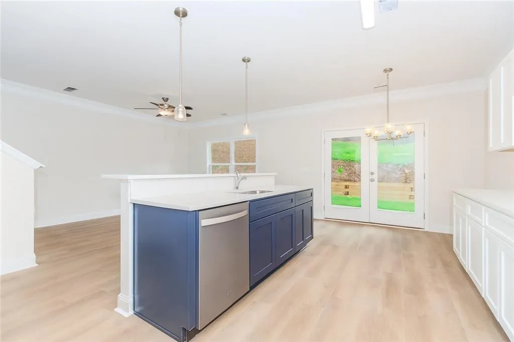 Kitchen featuring decorative light fixtures, dishwasher, a ceiling fan, light wood-type flooring, and ornamental molding