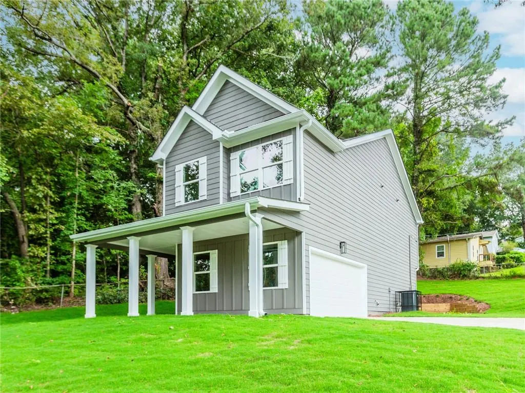 View of front of home featuring a front yard, an attached garage, driveway, a porch, and board and batten siding