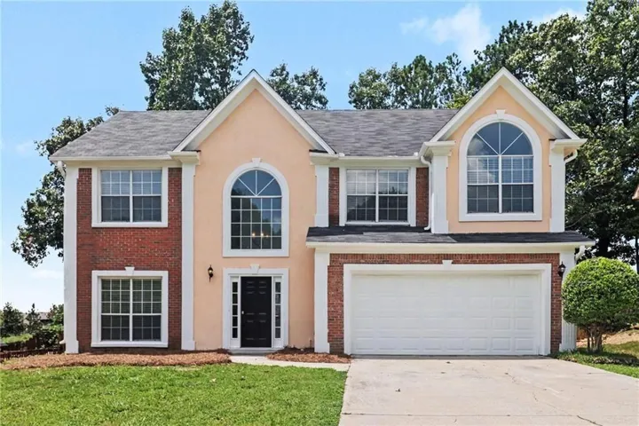Two-story exterior featuring brick and stucco siding