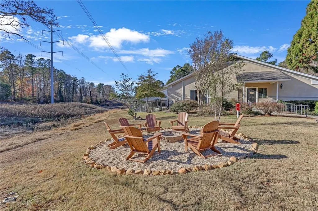 View of green lawn with an outdoor fire pit and a patio