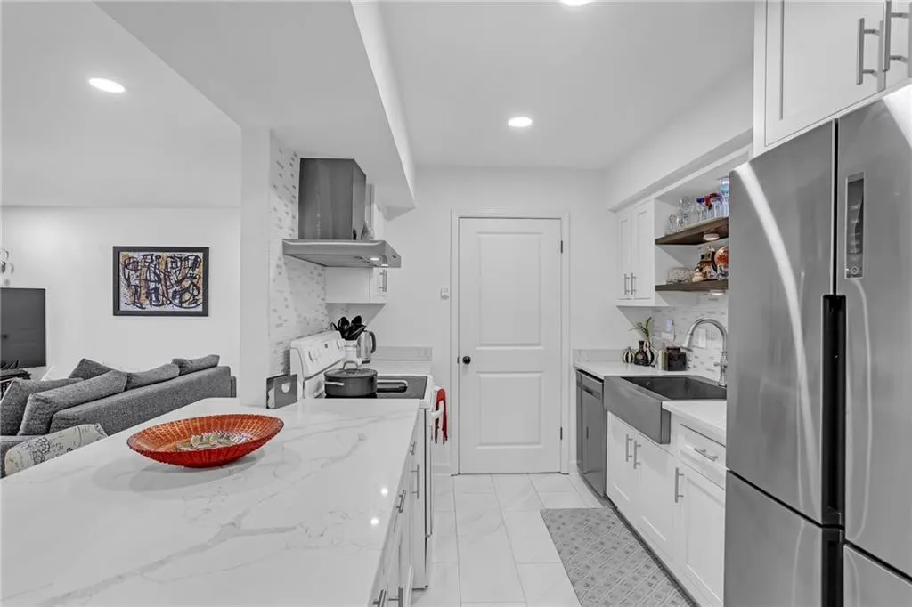 Kitchen featuring stainless steel appliances, white cabinets, backsplash, and recessed lighting