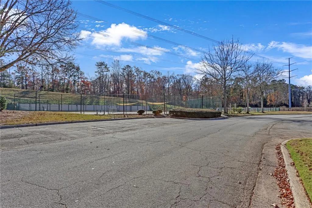 View of asphalt street featuring curbs and view of scattered trees