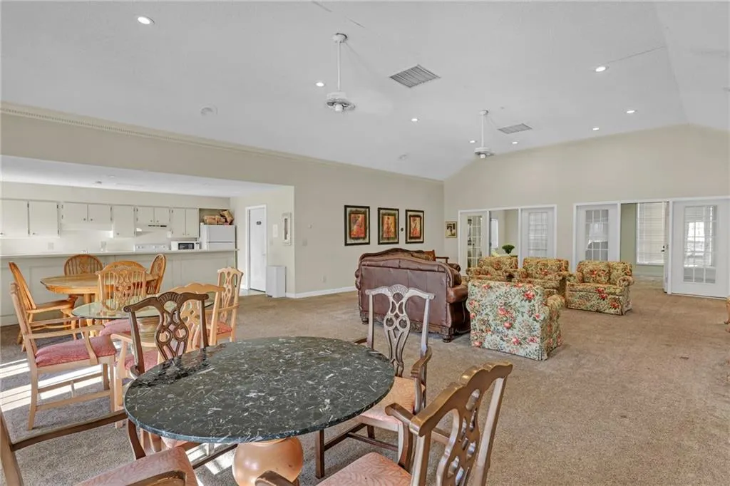Dining space with light colored carpet, vaulted ceiling, and recessed lighting