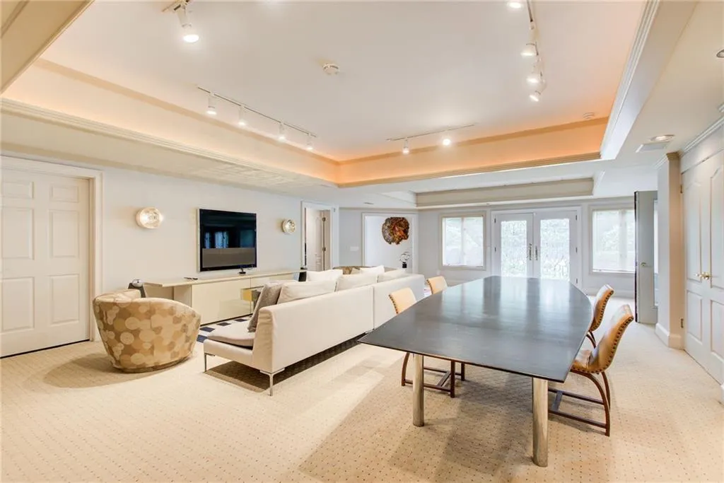 Terrace level living room with track lighting, double door exterior entry, and a tray ceiling