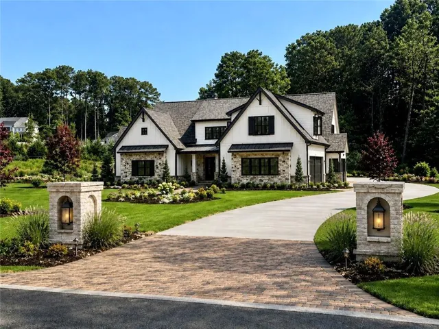 Rendering of Stone and siding exterior with dark trim accents, a paved brick entrance, a concrete driveway, and mature landscaping.