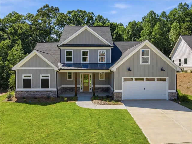 Craftsman-style home featuring board and batten siding, a metal accent roof, and a two-car garage