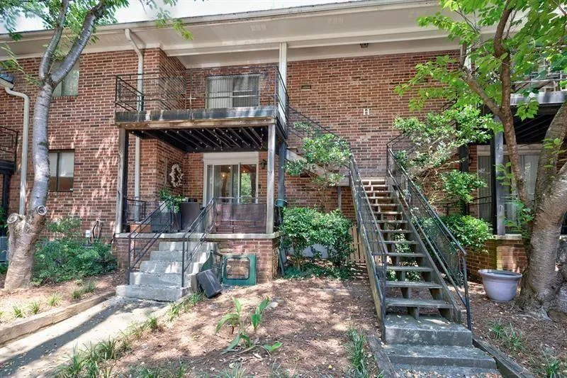 Rear entrance to property with brick siding and a covered balcony.