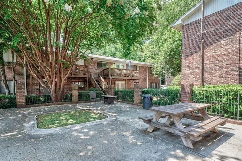 View of the patio area adjacent to the pool.  Has picnic tables and an area for grills.